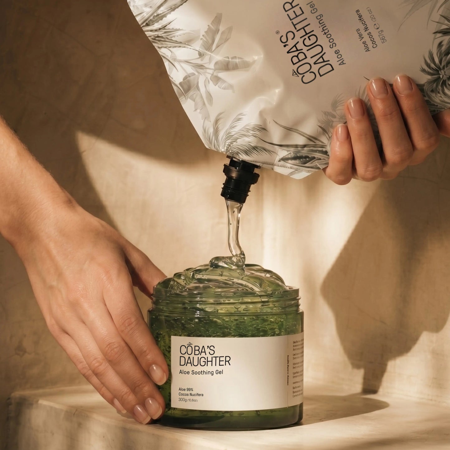 CoBa's Daughter aloe soothing gel being poured from a refill bag into the jar.