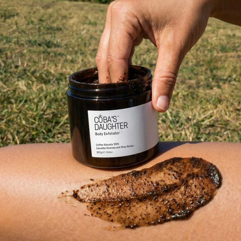 Person applying 'CoBa's Daughter' body exfoliator to their skin outdoors.