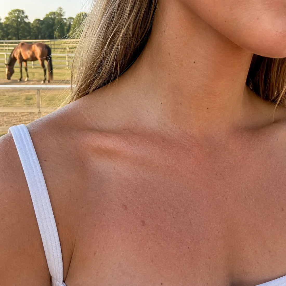 An equestrian's shoulder and neck area having an uneven, dull skin problem before using CoBa's Daughter Coffee Exfoliator