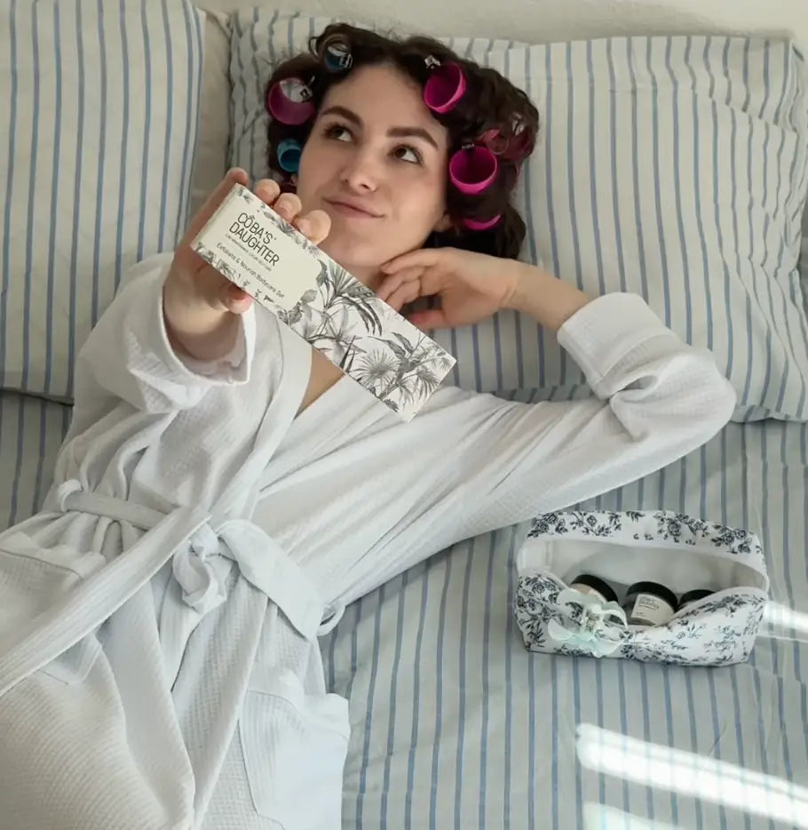 CoBa's Daughter 3-Piece Exfoliate and Nourish Gift Set during relaxing bedroom self-care routine with hair rollers