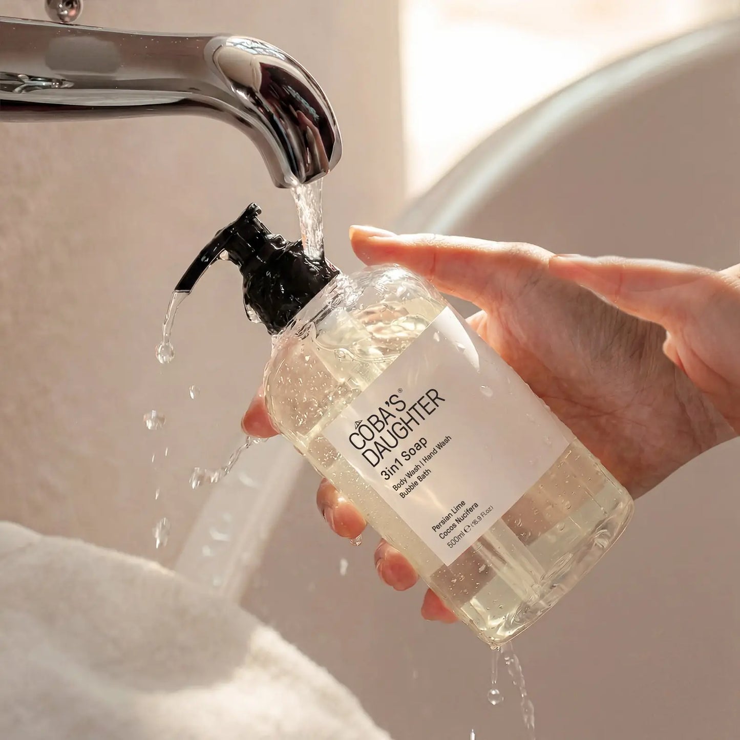 Refilling CoBa's Daughter 3in1 Body Wash Persian Lime and Cocos Nucifera pump bottle under running water