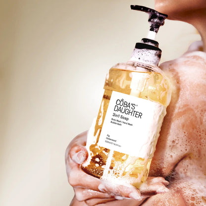 CoBa's Daughter 3in1 Soap bottle in Fig & Cedarwood scent being held by a woman with soap suds on hands and body.