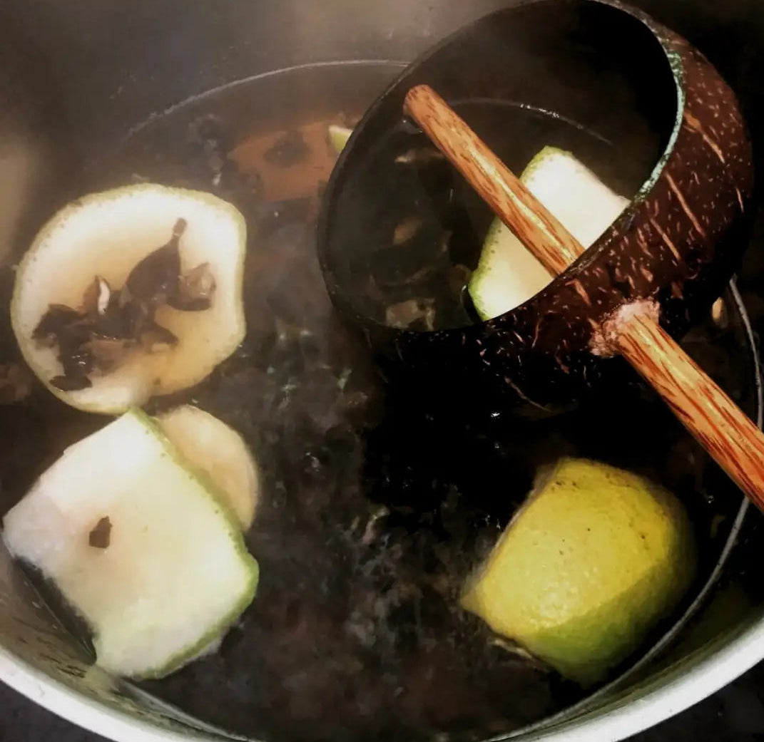 Herbal pot with grapefruit peel and star anise. Coconut shell is used to cook and stir the ingredients.
