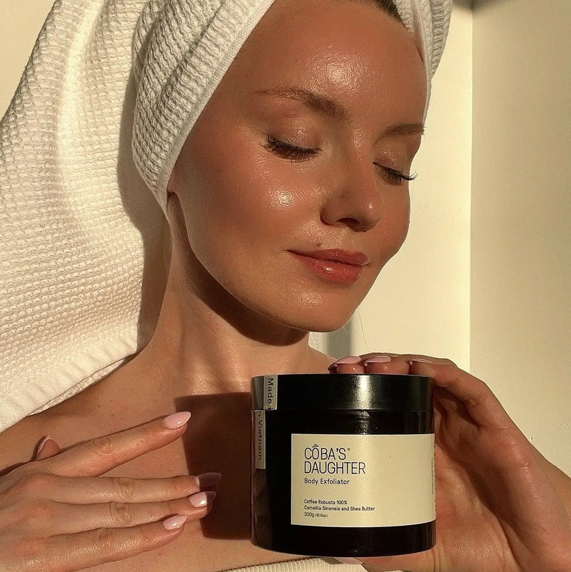 CoBa's Daughter Robusta Coffee Body Scrub in woman's hands with spa towel luxury skincare ritual