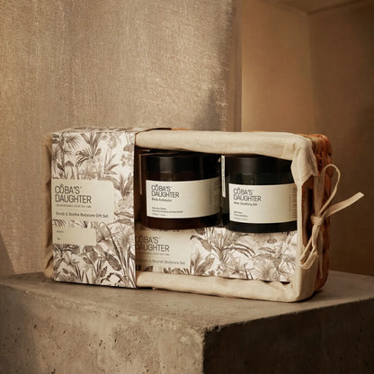 CoBa's Daughter gift set with two scrub and soothe body care products in a decorative box on a textured surface.